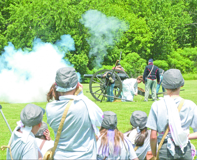 As some of the young Rebel soldiers cover their ears, General Kelly Meyer, fifth grade teacher and co-chair of the Civil War Day, pulls the lanyard to fire the 110-pound Parrott rifled cannon of the 9th Massachusetts Light Artillery.
