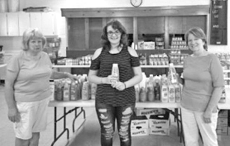 Emily Fabrizi (center), a sophomore at Suffield High School, holds a bottle of shampoo she collected for the Crossroads Food Pantry. With her in Fellowship Hall at the West Suffield Congregational Church are two volunteers from the food pantry, Miriam Blackaby (left) and Mary Calkins.