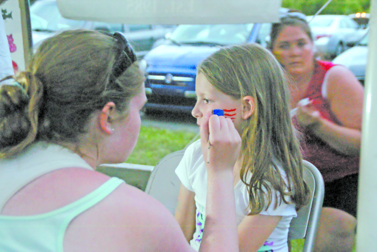 Kylis Tinnirella, 8, gets a patriotic emblem on her face.