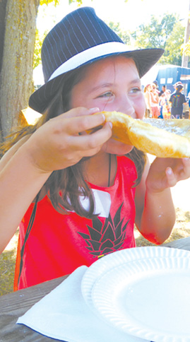 Alanna Dolan (8) really enjoys her fried dough and the cooler weather on Sunday afternoon.