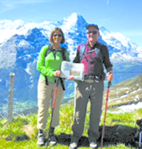 Joan and Tom Heffernan are pictured with their hiking sticks, and of course the Observer, in the glorious landscape of First, a minor summit served by a cable car above Grindelwald, Switzerland.  That’s the Eiger in the background.