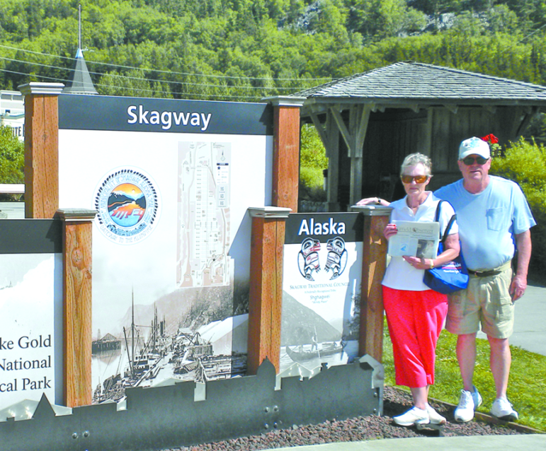 Enjoying the summer weather in Skagway, Alaska, Ralph and Donna Garside pose with The Suffield Observer at the entrance to the Klondike Gold Rush National Historical Park, where the White Pass crosses the coastal mountains, the gateway for gold miners.
