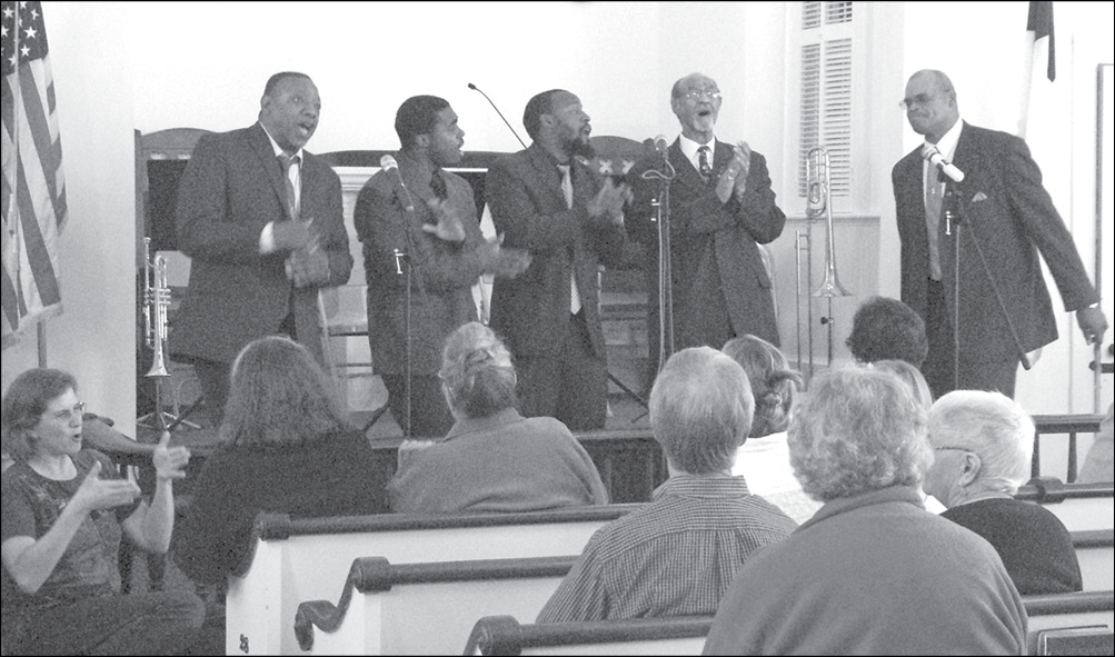 The men of the WNA Male Chorus of Suffield’s Third Baptist Church sang an impressive gospel medley at the September 25 afternoon concert of the Copper Hill United Methodist Church in East Granby. From the left, toward the climax of their “Amazing Grace” are: William Hill, Trystan Cauley, Jerome Hill, William Bowen, and Gregory Stewart. At far left, a signer fulfills the experience for several hearing-handicapped visitors.