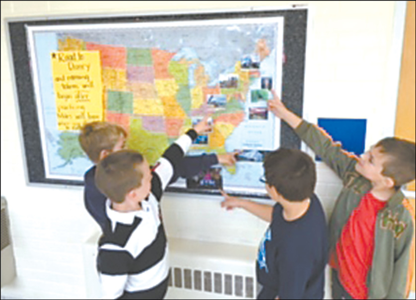 Second grade students check out the “destination board” of the Fun Feet recess initiative.