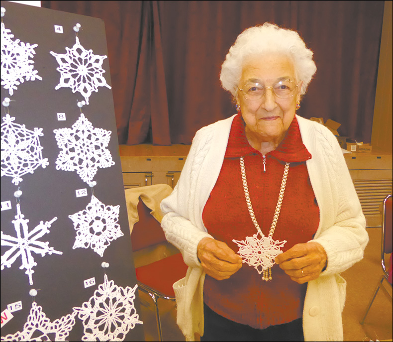 Mary Drenzek, age 93, offers her hand crocheted and starched Christmas snowflake ornaments in Fellowship Hall at the Second Baptist Church.