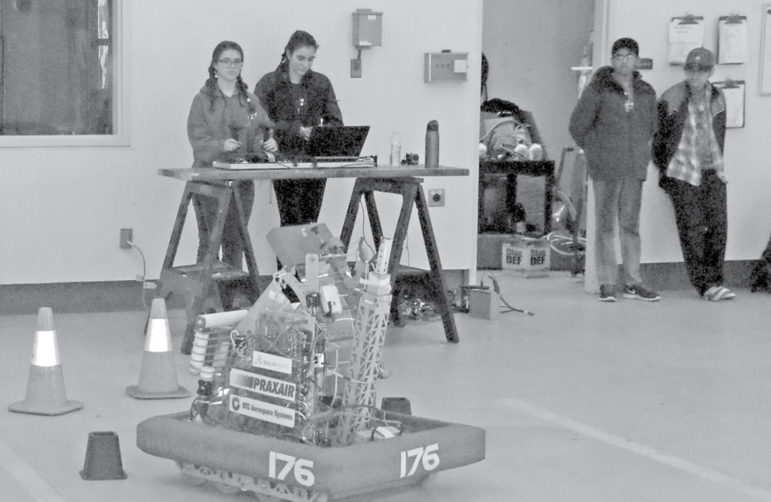 Preparing for the upcoming initial scrimmage of this season, the SHS-WL FIRST Robotics team practices with last year’s robot at the Zak Ambulance Center on January 15. From the left: Stephanie Devita driving the robot, Holly Tseka at the laptop, with Pranav Saravanan and Benjamin Ouellette waiting their turn.