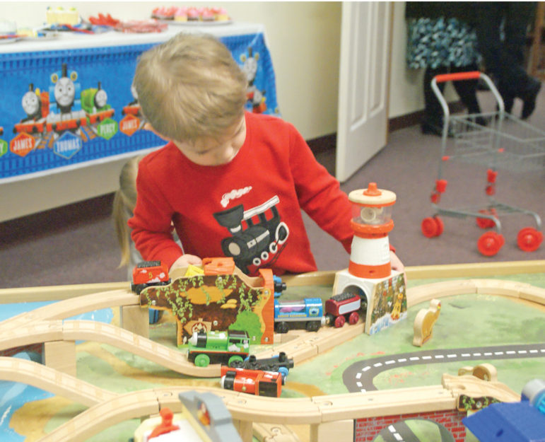Luke Osowiecki, 3, maneuvers some train cars through a tunnel on the library’s new Thomas the Train table, a gift from Judy Ahrens, Judy Fisher, and the Friends of the Library.