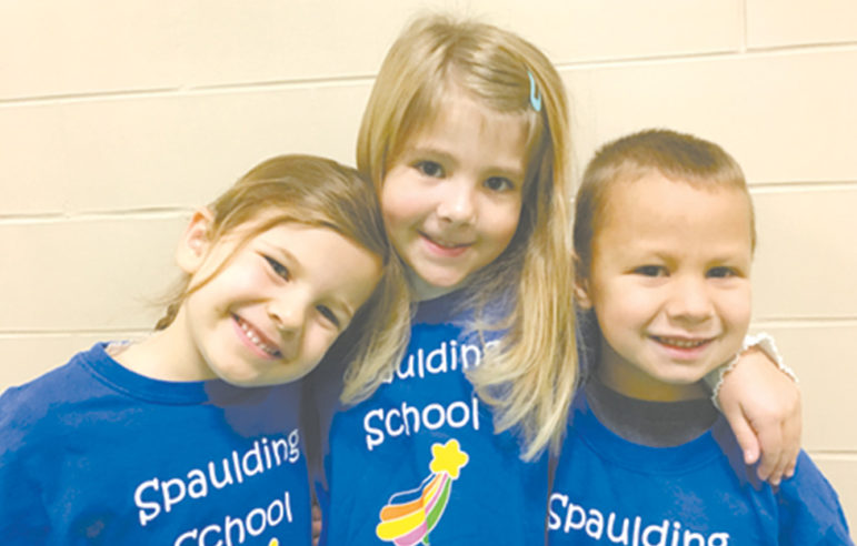 Kindergarten students (left to right) Liv Loescher, Kaitlyn Dudack and Owen Devanney pose in their Spaulding Stars t-shirts during the school’s recent assembly on responsibility.