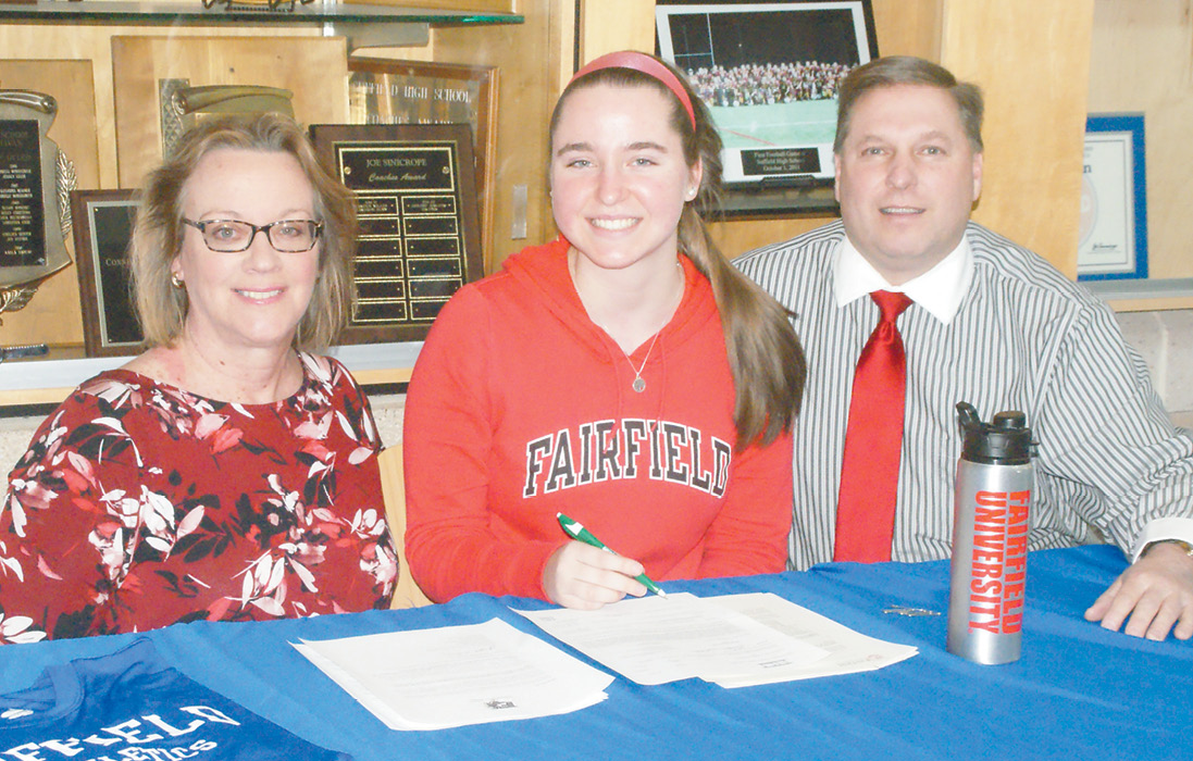 Suffield High School soccer star Nicole Stryjek signs to accept a scholarship at Fairfield University. With her are her proud parents, Ann and John.