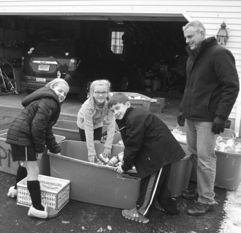 With some help for the heavy loads, the Nikolis kids sort their weekly redeemables collection into bins for glass, aluminum, and plastic. From the left: twins Ariana and Maggie, James, and their father, Chris.