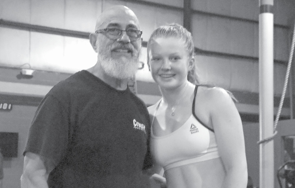 Jenna Salter, a sophomore at Suffield High School who exercises at the gym on Ffyler Place, poses with noted CrossFit athlete Jacinto Bonilla. The aged athlete, 77 and still impressively fit, was visiting the Land Warrior CrossFit gym in Suffield to set a good example and motivate the hard-working enthusiasts who work out there.
