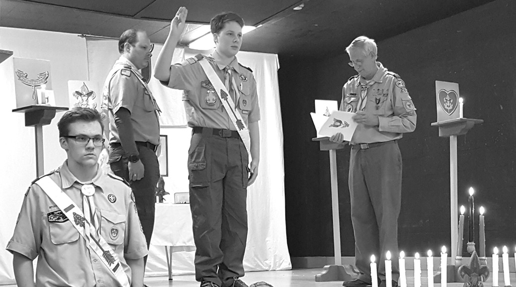 New Eagle Scout John Cremmins recites the Eagle Scout pledge administered by Assistant Scoutmaster Art Sikes, right, with Senior Patrol Leader Mickey Barron at front left. Behind John are his father, Scoutmaster Mike Cremmins, and mother, Angela, hidden behind her husband. For John's Eagle Scout service project, he built a pair of "buddy benches" for the Spaulding School playground. Troop 260's ceremony took place at Second Baptist Church on March 21.