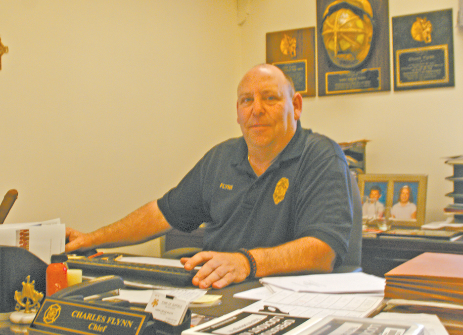 Now honored in the Connecticut Firefighters Hall of Fame, Suffield Fire Chief Chuck Flynn is pictured at his desk in Fire Station Number One.