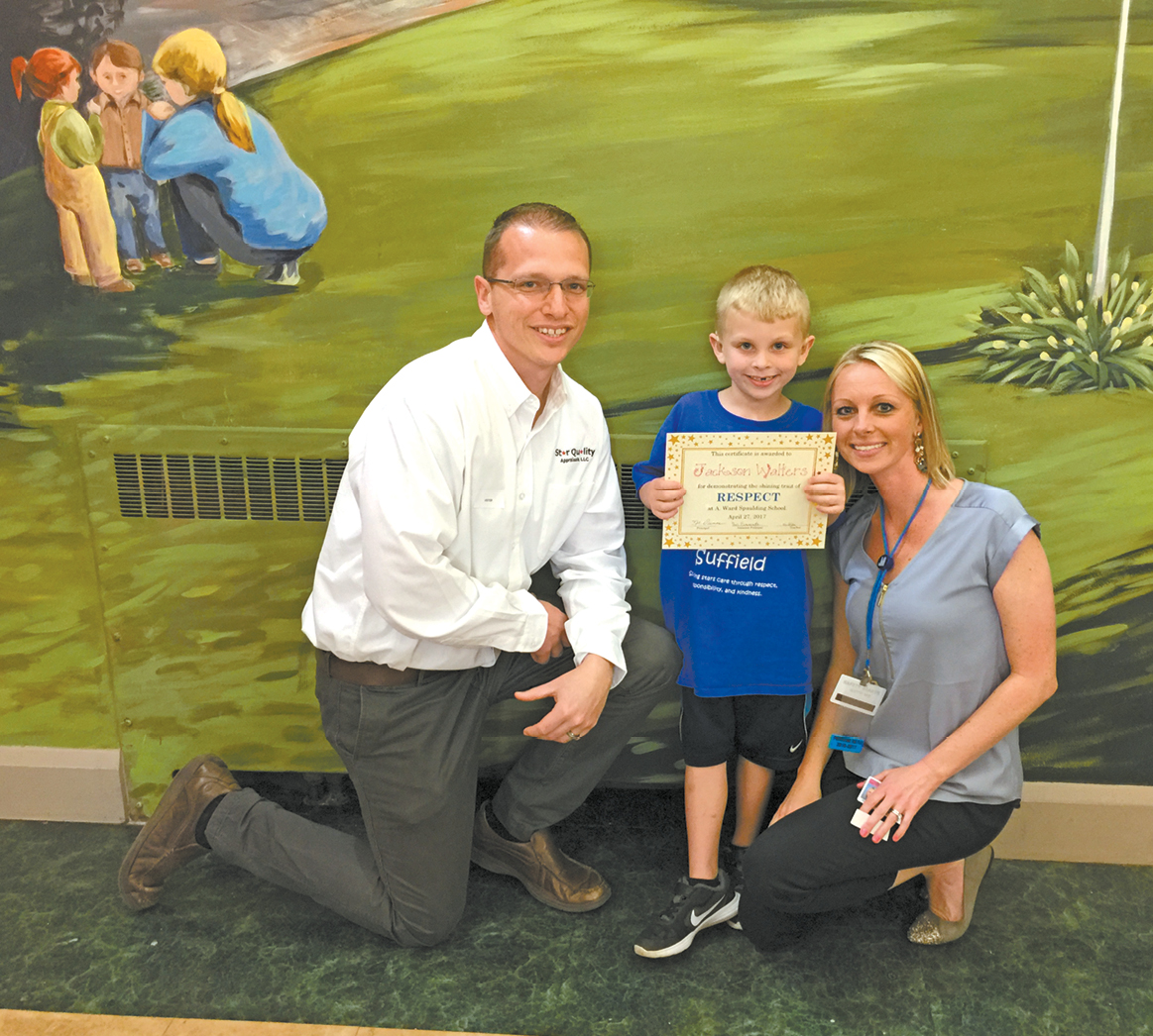 Kindergarten student Jackson Walters proudly poses with his parents and respect certificate.