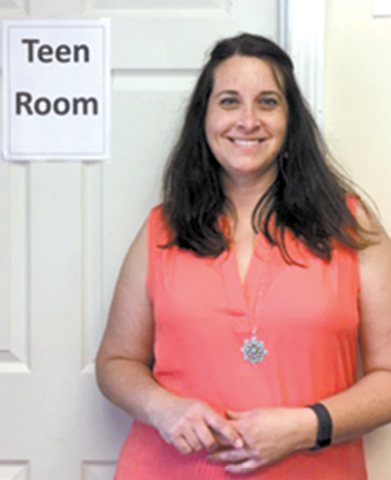 New Teen Outreach Coordinator Wendy Mitzel is pictured at the door to the temporary library’s Teen Room, which seldom needs to be closed.