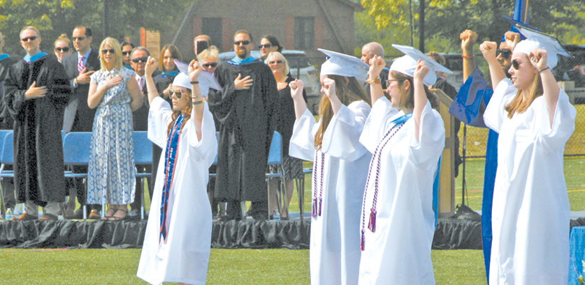 In a surprise feature of the SHS graduation, students from the school’s new course in American Sign Language translated the Pledge of Allegiance and the National Anthem. Behind them on the dais in the photo are members of the Board of Education and the school administration.