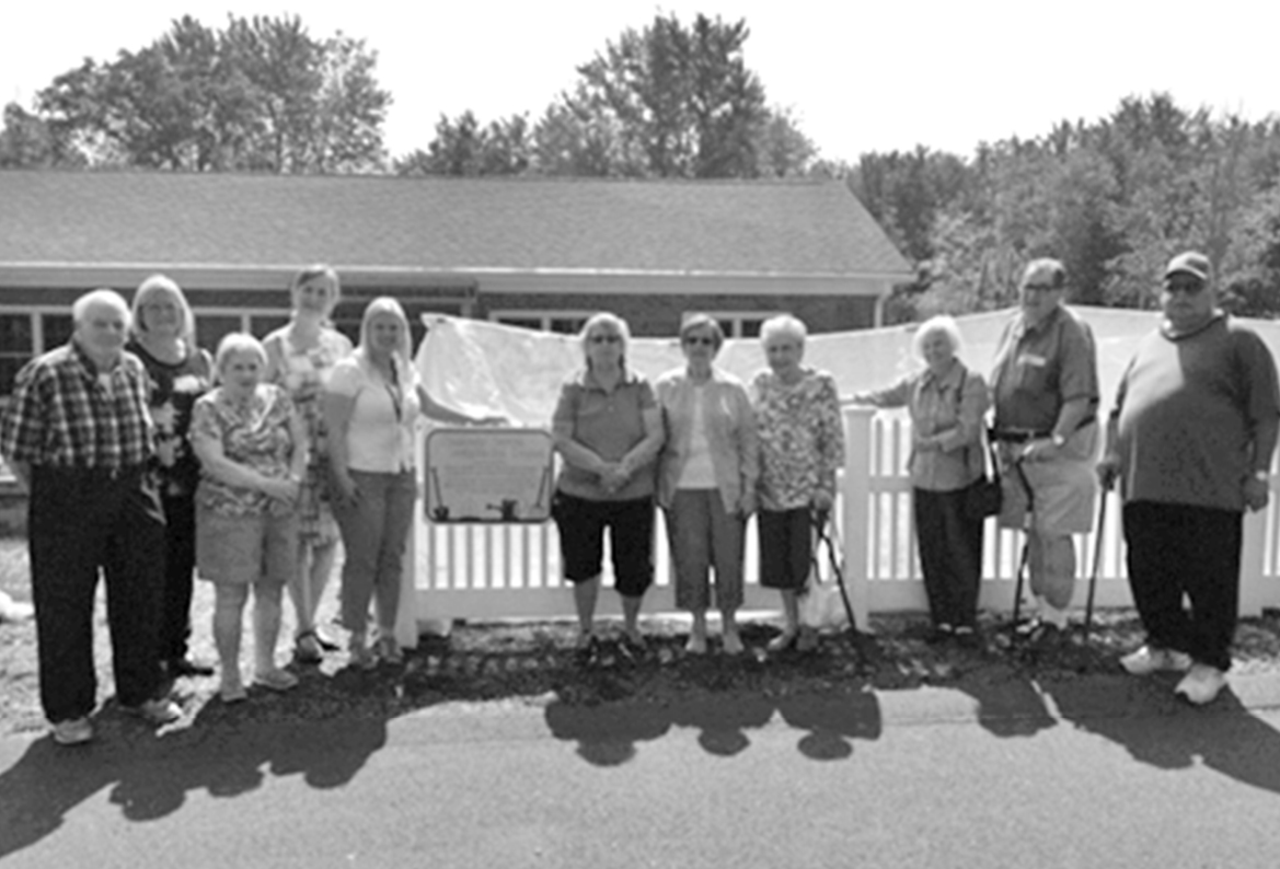 Interested gardeners pose for a portrait after the ceremony at the revitalized Senior Center garden.  From the left: Duke Marotta, Paula Pasco, Terry Torre, Kathleen Mack (Home Helpers of North Central Connecticut), Joanna Keyes (Public Health Educator for the North Central District Health Department), Diane Hale, Phyllis Tanguay, Helen Price, Helen Curry, Ron Hale and Wilber Lowdermilk.