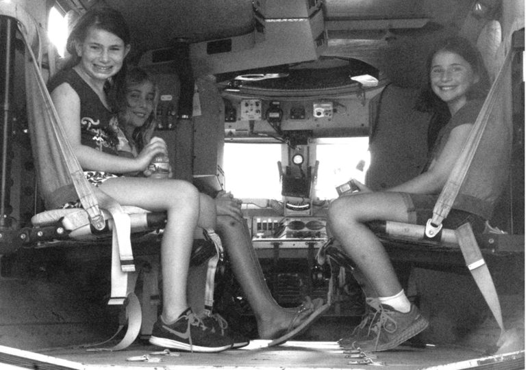 Three Suffield Middle School friends get a kick out of sitting in this heavily armored vehicle from the regional Emergency Services team. From the left: Elizabeth Mack, Wren Gomes, Sarah Michael.