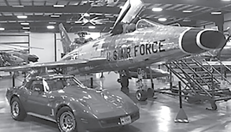 In the New England Air Museum’s military hangar, a shiny bright Corvette is pictured next to an equally bright but half-century-older F-100 Super Sabre.