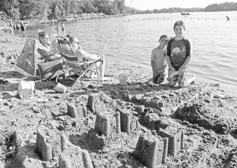 Julian Golden, 6, and his uncle, Dylan True, 11, pose with their winning sand castle at Babb’s Beach on July 19.  Mother Michelle Golden and Grandmother Kimberly Goldern are sitting nearby.