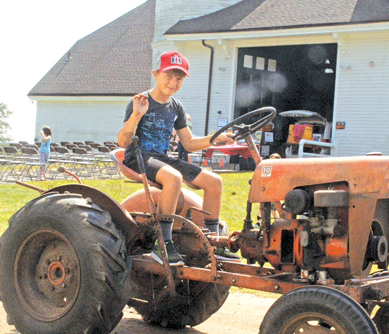 Lucas Kaplan of Hastings Farm, 9, pilots his 60-year-old Power King around the Hilltop Farm barn in the Farm Fest tractor parade.