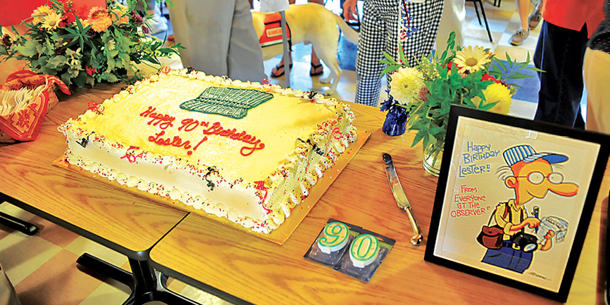 Photo by Ray Pioggia “Conductor hat” cake (donated by Highland Park Market), flowers (donated by Suffield Garden Club) and Rick Stromoski’s caricature of Lester.