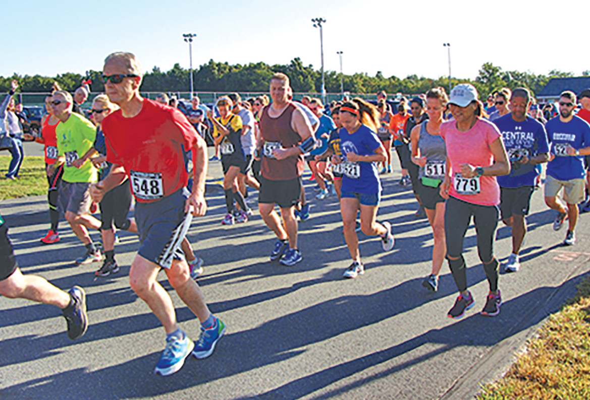 Chasing their shadows in the early morning start, a throng of runners set out on the Middle School parking lot in the Parks & Rec annual 10K Road Race.