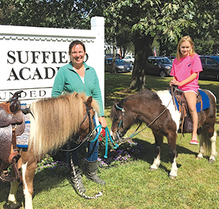Sophia Romaniw (right), age 9, is poised to ride on one of the two ponies provided by Star Pony Parties & Events of Granby – an exciting new addiiton to this year’s Suffield on the Green. Pony owner Kristen Strain (left) is standing by, preparing to lead Sophia on a ride.