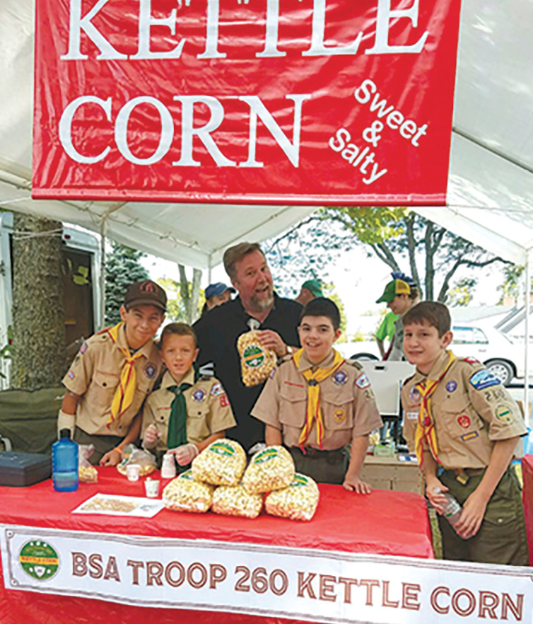 Rick Stromoski looks forward to eating his popcorn purchased from Scouts of Troop 260. From the left;  Wyatt Cashman, Logan Cerkanowicz, Johnny Balsamo and Sam Sikes.