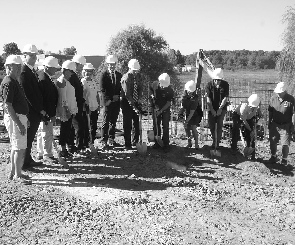 First Selectman Melissa Mack (fourth from right) tosses another shovelful during the symbolic groundbreaking ceremony held on September 28 at the future site on South Street of the Broad Brook Brewery.