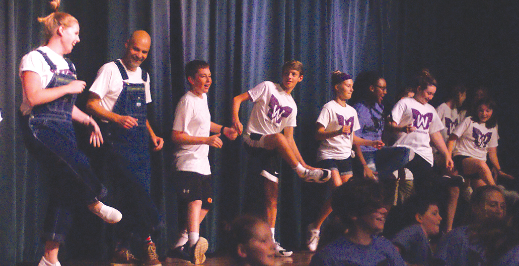 An enthusiastic Wingman Flight Crew, led by Assistant Principal Ashley Eichorn and Principal Damon Pearce at the left, presented a happy dance act for the talent contest in the opening rally of Suffield Middle School’s Wingman program.