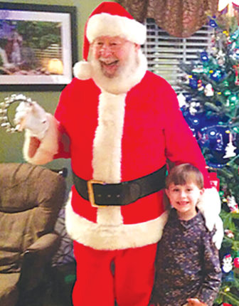 Logan Laitinen, age 6, of Suffield, is all smiles standing with Santa last December.