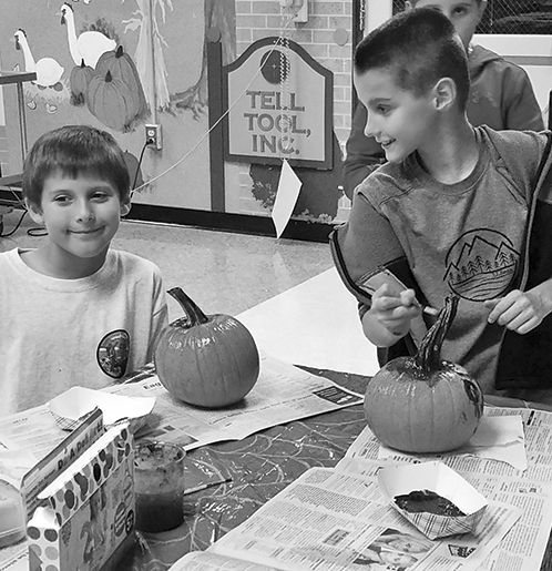 At one of Parks & Rec’s after-school programs in Spaulding School, Sam Zabik, right, interrupts his pumpkin painting to confer with Ethan Boldt.