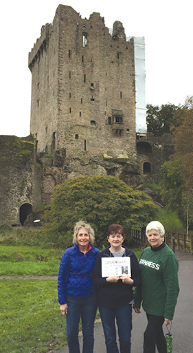 Kathy Krar holds the Observer, with Ginny Bromage, left, and Dian Friedman during their visit to Blarney Castle in County Cork, Ireland.