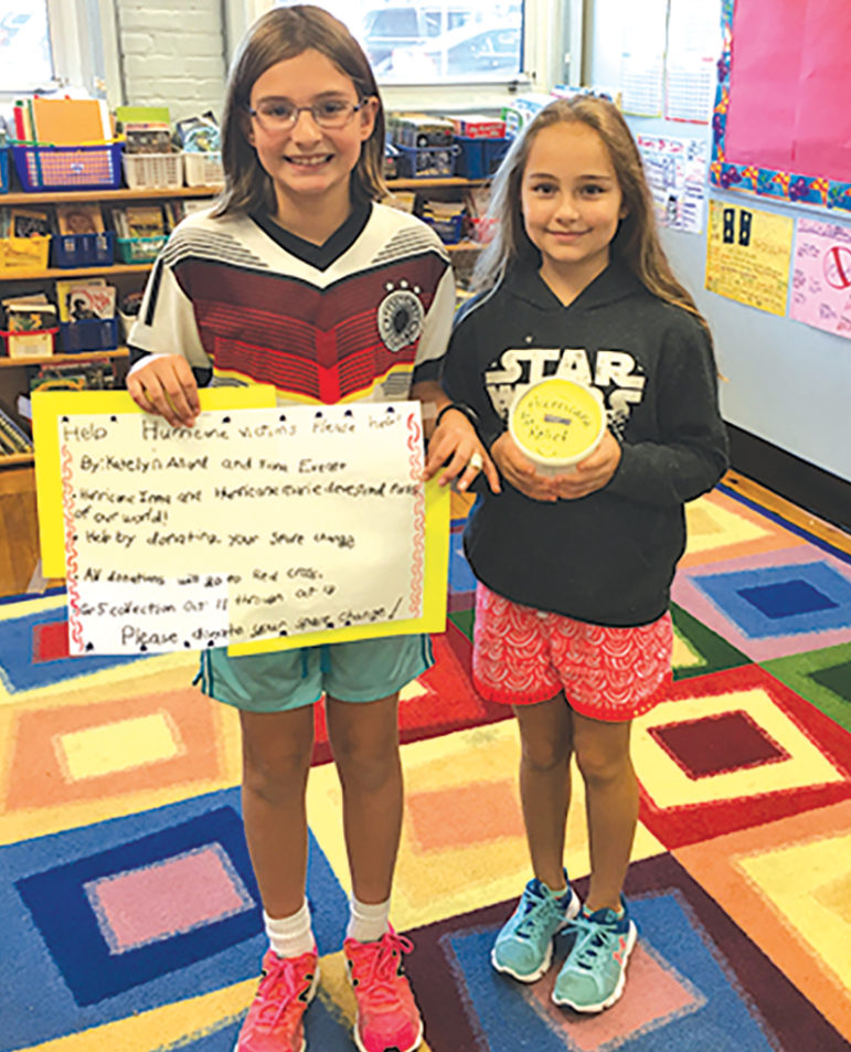 Showing examples of the posters and collection banks they employed  to collect Florida hurricane relief are McAlister fifth graders Katelyn Allard, left, and Fiona Everett.
