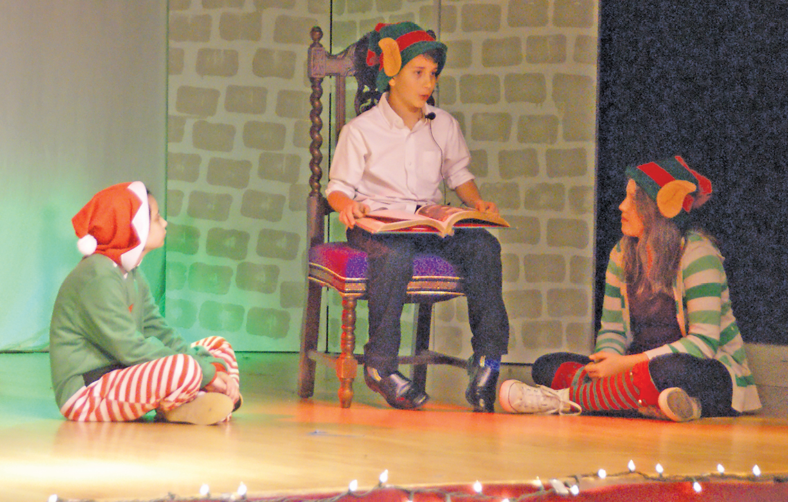 Joseph Colangelo reads “’Twas the Night Before Christmas” to an attentive duo of elves, Avaliese Hitchcock and Janine Eitel. The performance was one of the enjoyable acts of the Suffield Youth Theater’s seasonal presentation on December 10.