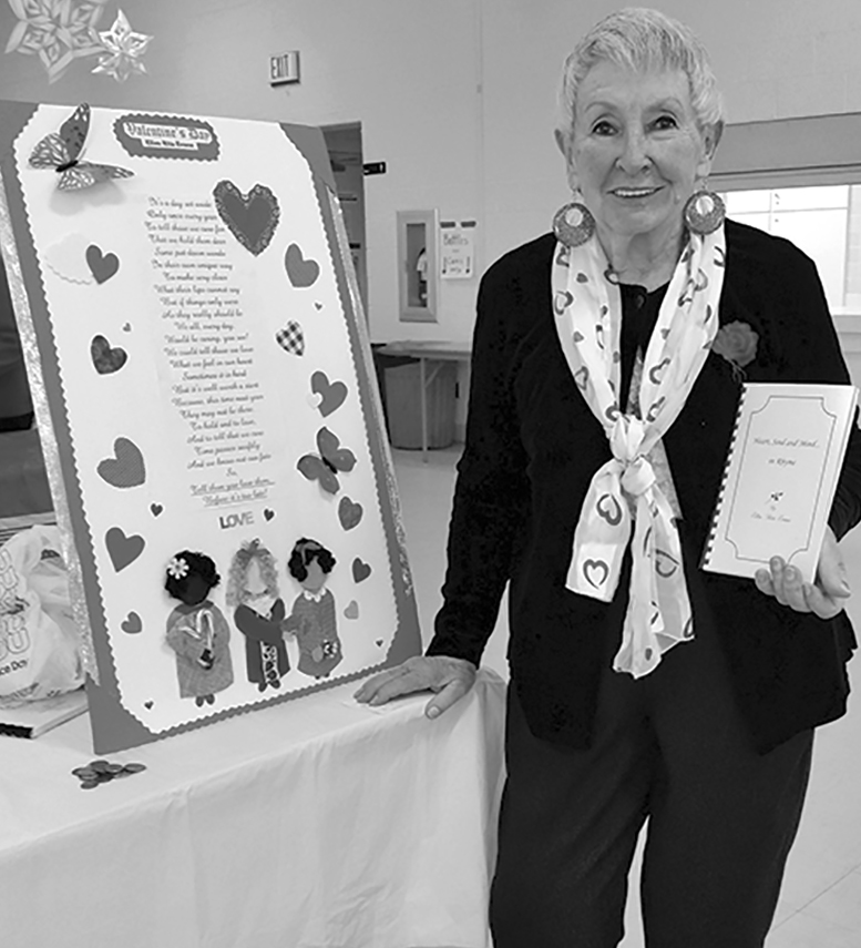 Poet Ellen Rita Evans is pictured with one of her books at the February meeting of the SWC in Fr. Ted Hall.